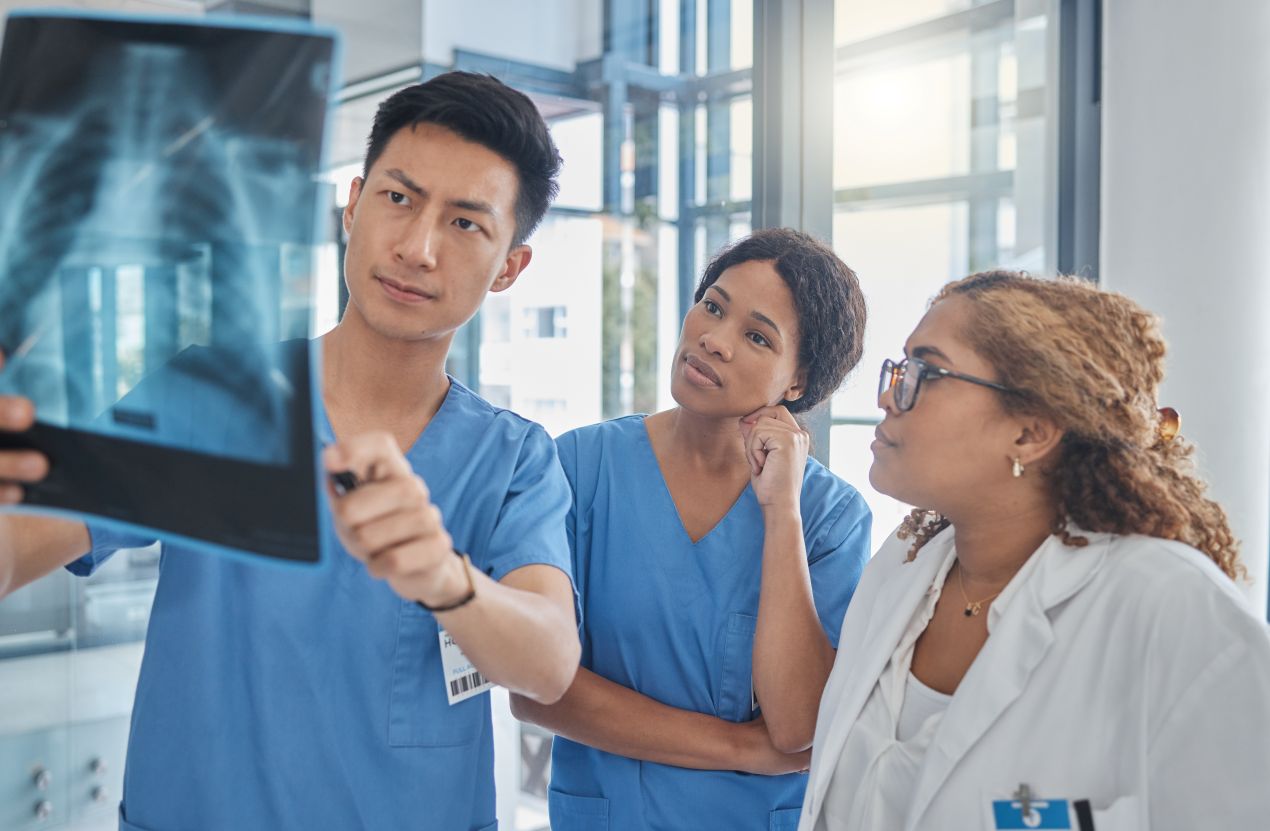 Ein Team aus Radiologen und medizinischem Fachpersonal untersucht eine Röntgenaufnahme in einer Radiologie-Praxis in Düsseldorf.