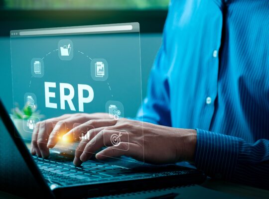 Person nutzt Laptop mit eingeblendetem ERP-System