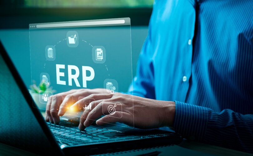 Person nutzt Laptop mit eingeblendetem ERP-System