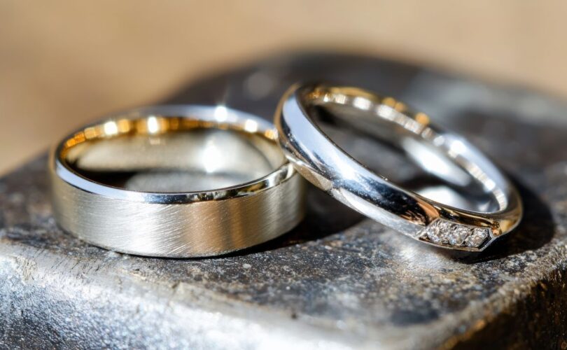 Zwei Eheringe Platin auf Metallblock – hochwertiger Schmuck mit Struktur und Diamantbesatz