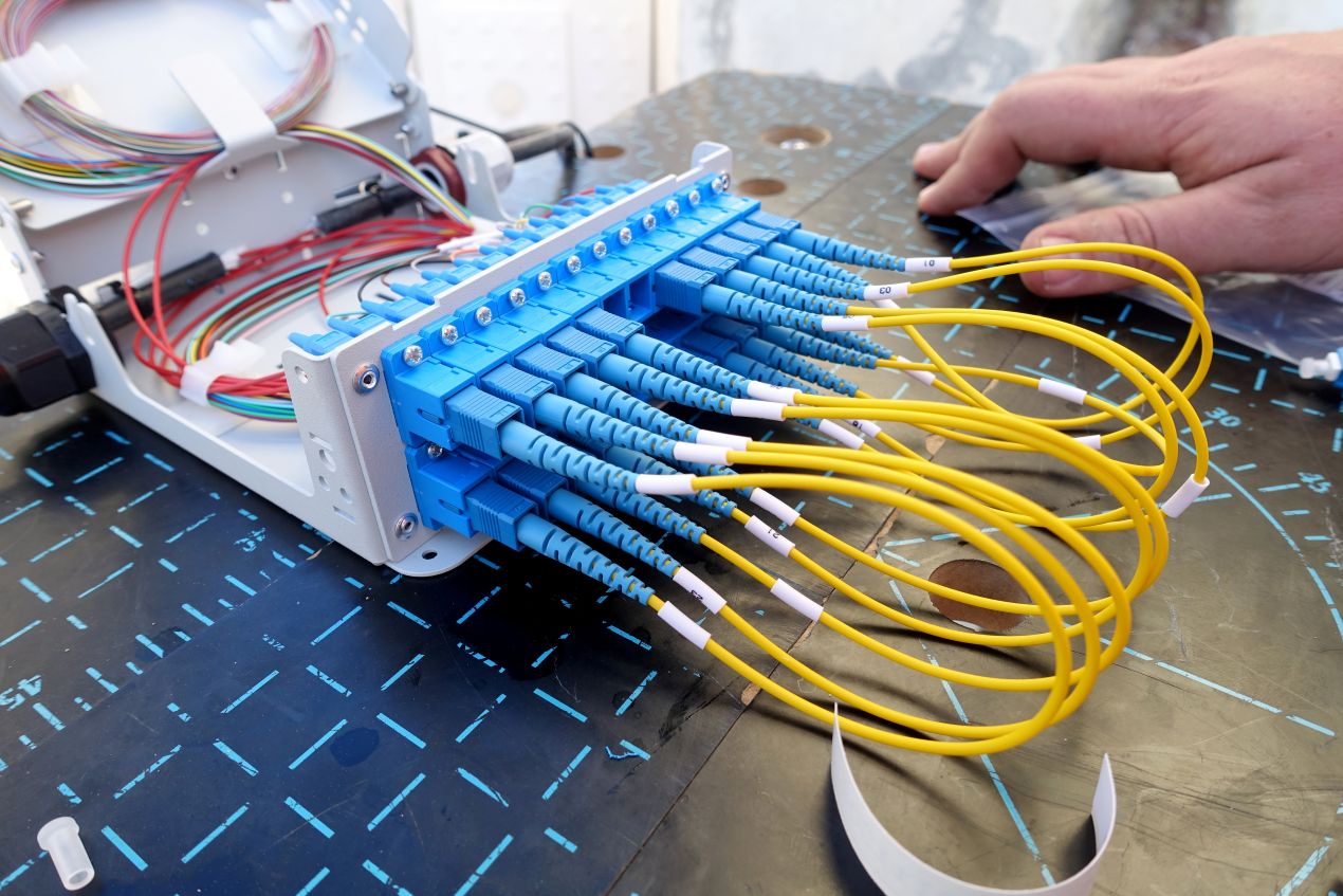 Voll bestuecktes Glasfaser-Patchfeld mit gelben LC-Patchkabeln – MTP kompatible Verbindungstechnik in professioneller Infrastrukturumgebung.