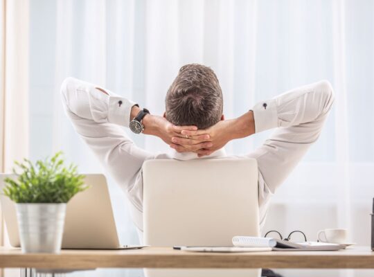 Mann entspannt im Büro am Schreibtisch, ergonomische Bürostühle