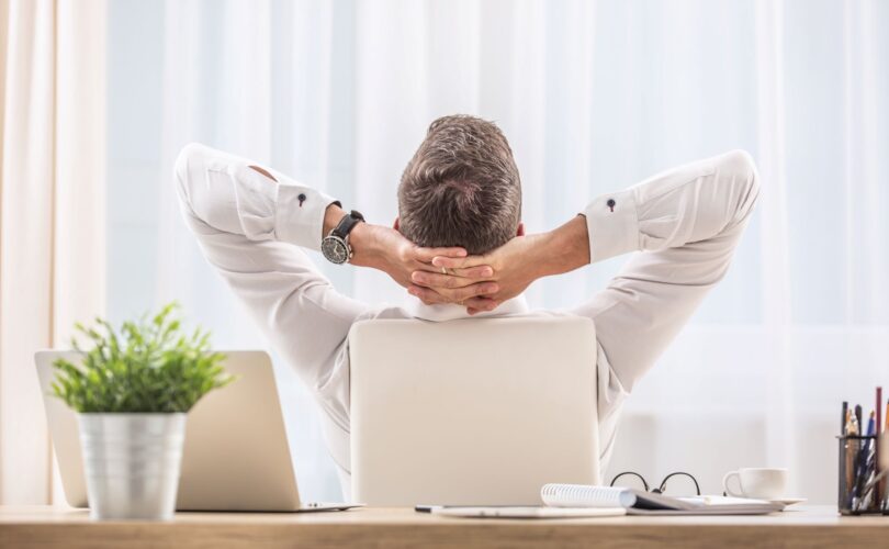 Mann entspannt im Büro am Schreibtisch, ergonomische Bürostühle